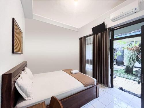 a bedroom with a bed and a large window at Indonesia Hotel Malioboro in Yogyakarta