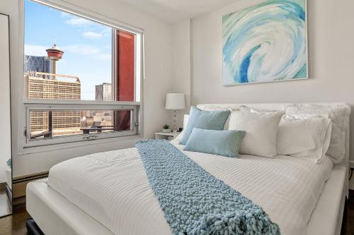 カルガリーにあるThe Prime Downtown | Luxe Condo + Free Parkingのベッドと大きな窓のある寝室