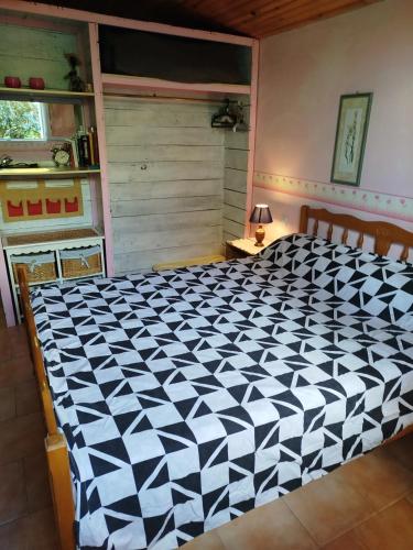 a bedroom with a large black and white bed at Gîte de vincés Lot-et-Garonne situé entre Bordeaux et Toulouse maison rurale, Maison en campagne in Tombeboeuf