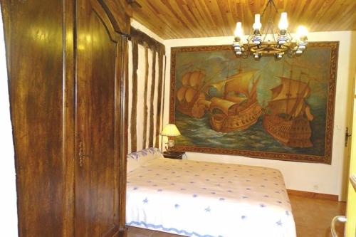 a bedroom with a painting on the wall and a bed at Gîte de vincés Lot-et-Garonne situé entre Bordeaux et Toulouse maison rurale, Maison en campagne in Tombeboeuf