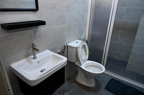 a bathroom with a white toilet and a sink at CK Home in Ipoh