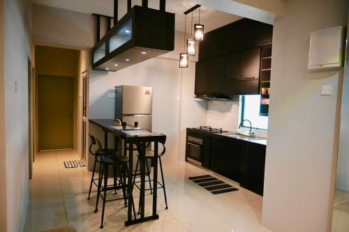 a kitchen with a counter and stools in it at CK Home in Ipoh