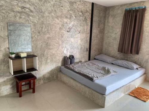 Schlafzimmer mit einem Bett und einem Beistelltisch in der Unterkunft Rakchayanin Resort Koh Larn in Ko Larn