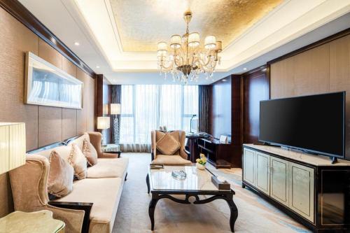 a living room with a couch and a flat screen tv at Chengdu Rising Butterfly Hotel in Chengdu