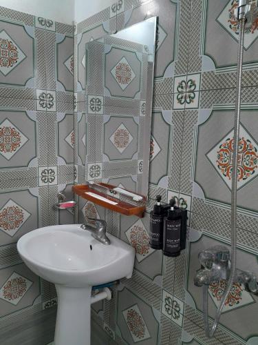 a bathroom with a sink and a mirror at Mina Café & Stay in Quan Lạn