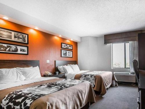 two beds in a hotel room with orange walls at Sleep Inn Bessemer Helena in Bessemer