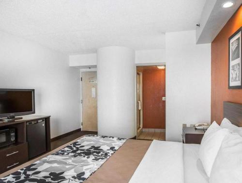 a hotel room with a bed and a flat screen tv at Sleep Inn Bessemer Helena in Bessemer
