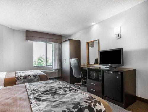a hotel room with a bed and a flat screen tv at Sleep Inn Bessemer Helena in Bessemer