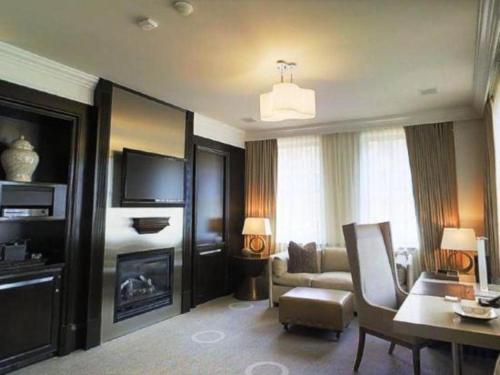 a living room with a couch and a fireplace at Fifteen Beacon Hotel in Boston