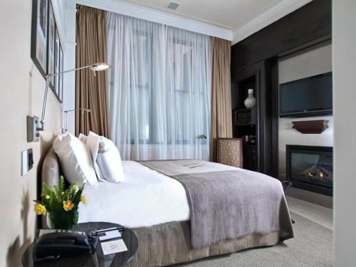 a hotel room with a bed and a fireplace at Fifteen Beacon Hotel in Boston
