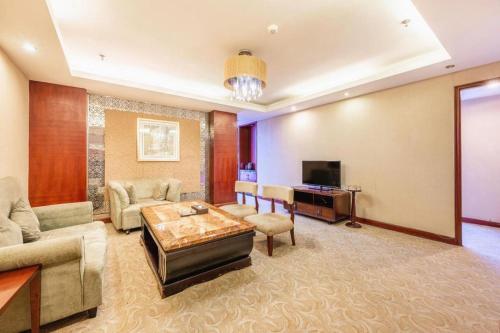 a living room with a couch and a tv at Xian Union Alliance Atravis Executive Hotel in Xi'an