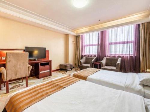 a hotel room with a bed and a television at Xian Union Alliance Atravis Executive Hotel in Xi'an