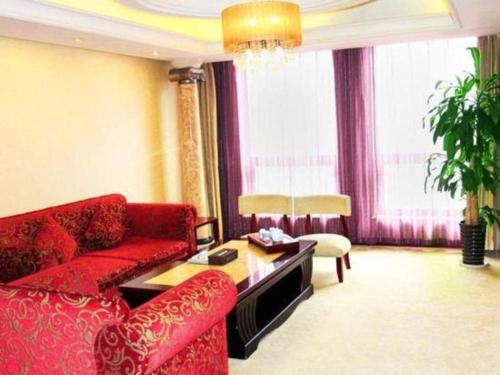 a living room with a red couch and a table at Xian Union Alliance Atravis Executive Hotel in Xi'an