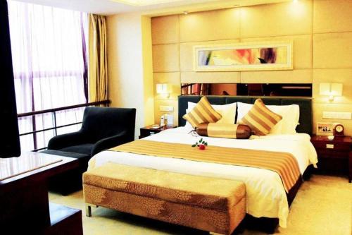 a hotel room with a large bed and a chair at Xian Union Alliance Atravis Executive Hotel in Xi'an