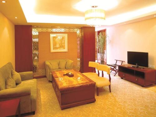 a living room with a couch and a tv at Xian Union Alliance Atravis Executive Hotel in Xi'an