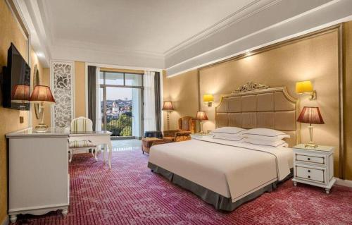 a bedroom with a large white bed and a desk at Country Garden Phoenix Hotel Changsha in Xingsha