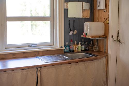 a kitchen with a sink and a window at Private Plan Torpet Cabin in Södra Ström
