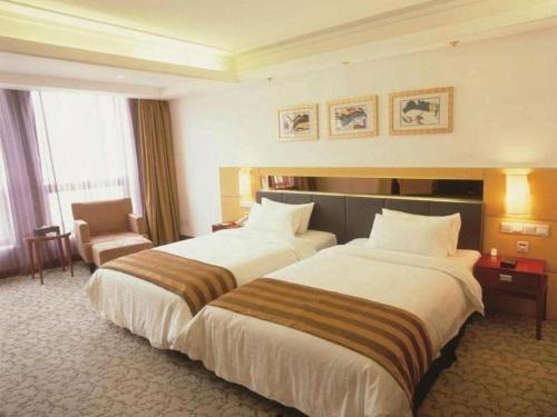a hotel room with two beds and a chair at Xian Union Alliance Atravis Executive Hotel in Xi'an