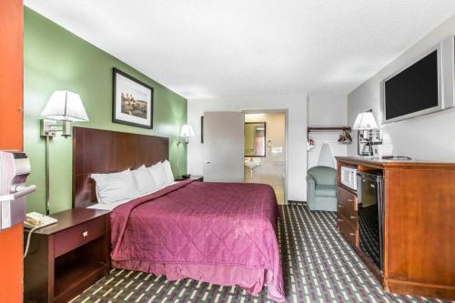 a hotel room with a bed and a flat screen tv at Quality Inn Homewood Birmingham I-65 in Birmingham