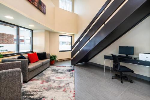 a living room with a couch and a desk and a staircase at Comfort Inn Gatineau in Gatineau