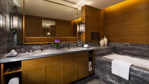 a bathroom with two sinks and a tub and a large mirror at Hyatt Regency Changbaishan in Fusong