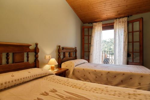 a bedroom with two beds and a window at Apartaments Populetus in Poboleda