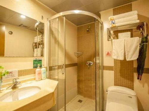 a bathroom with a shower and a toilet and a sink at Huangshan Yupinglou Hotel in Huangshan