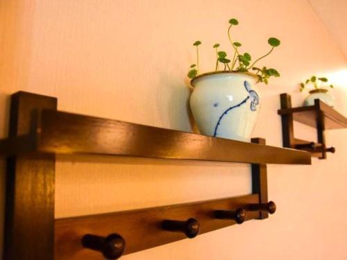 a vase sitting on top of a shelf with a plant at Huangshan Yupinglou Hotel in Huangshan