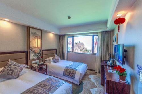 a hotel room with two beds and a window at Huangshan Yupinglou Hotel in Huangshan