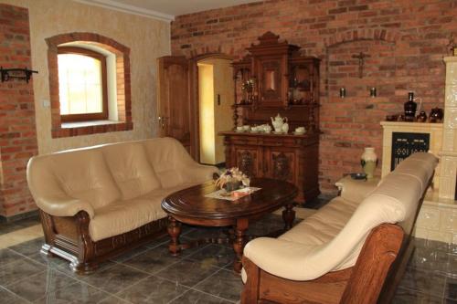 ein Wohnzimmer mit einem Sofa und einem Tisch in der Unterkunft Pensjonat Florentyna in Warnice