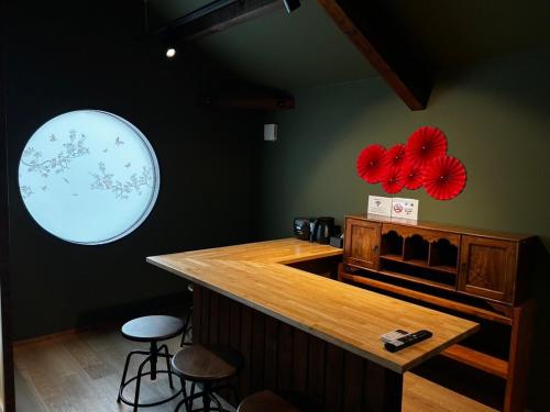 a bar in a restaurant with red paper flowers on the wall at ゲストハウス彦根銀座 in Hikone