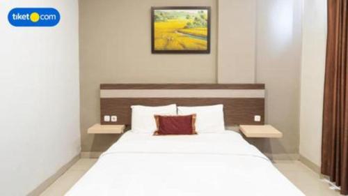 a bedroom with a large white bed in a room at Raffleshom Hotel in Bandung