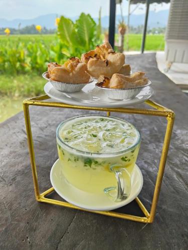 a yellow bowl of soup and pastries on a stand at Junior Suite Nature of Penang Guesthouse in Balik Pulau