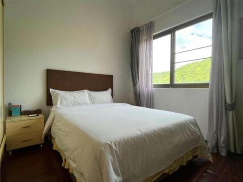 a bedroom with a large bed and a window at The Century Seaview Hotel in Shenzhen