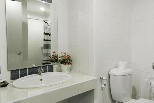 a white bathroom with a sink and a mirror at Urban House 195 in Chiang Mai