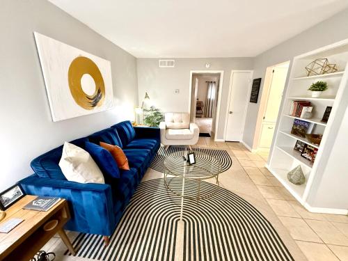 a living room with a blue couch and a table at Spotless Full Sized Apartment! Montrose Stays An Art Lover's Dream in Houston