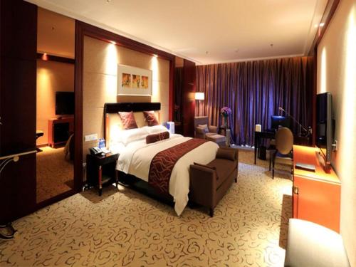 a hotel room with a large bed and a desk at Northwest Petroleum Hotel in Ürümqi