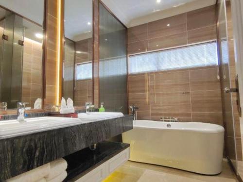 a bathroom with two sinks and a bath tub at The Century Seaview Hotel in Shenzhen