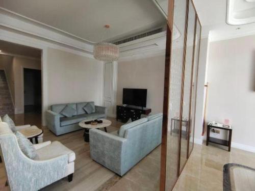 a living room with two couches and a tv at The Century Seaview Hotel in Shenzhen