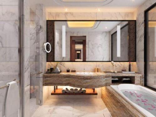 a bathroom with a tub and a large mirror at Northwest Petroleum Hotel in Ürümqi