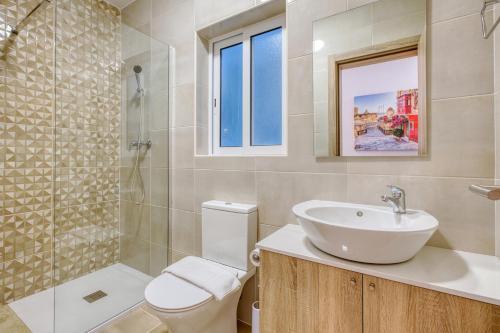a bathroom with a sink and a toilet and a shower at New! Spacious 4-Bedroom Duplex apartment by SF Homes in Tal-Ħriereb