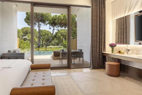 a living room with a view of a pool at Kempinski Hotel The Dome Belek in Belek