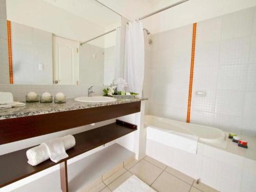 Un baño blanco con bañera y lavabo. en Terranova Suites, en Santa Cruz de la Sierra