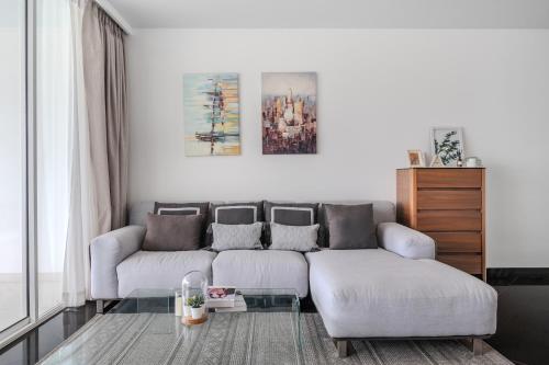 a living room with two couches and a table at Pure Sunset Beach - Ocean View Room, Pattaya in Na Jomtien