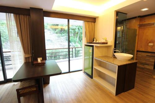 a bathroom with a sink and a glass shower at Phi Phi Nice Beach Hotel Hip in Phi Phi Don