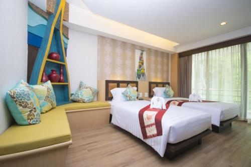 a bedroom with two beds and a window at Phi Phi Nice Beach Hotel Hip in Phi Phi Don