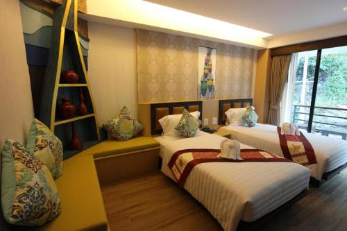 a hotel room with two beds and a window at Phi Phi Nice Beach Hotel Hip in Phi Phi Don