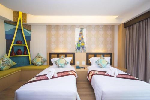 two beds in a hotel room with two beds sidx sidx sidx at Phi Phi Nice Beach Hotel Hip in Phi Phi Don