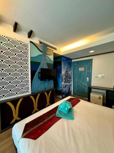 a bedroom with a large bed with towels on it at Phi Phi Nice Beach Hotel Hip in Phi Phi Don