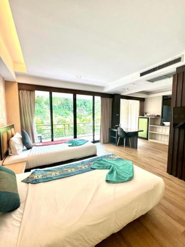 a hotel room with two beds and a large window at Phi Phi Nice Beach Hotel Hip in Phi Phi Don